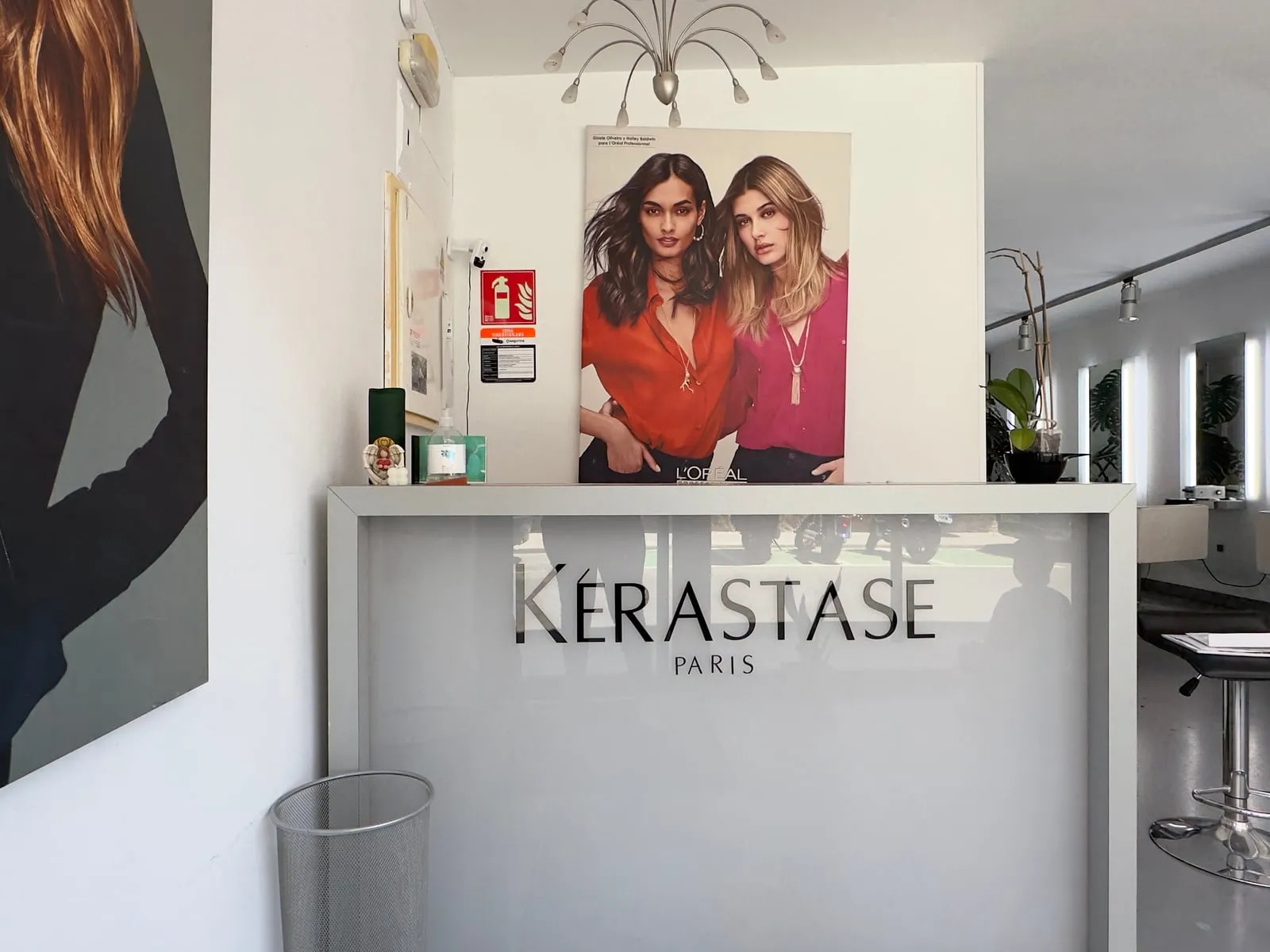 Recepción con el mostrador serigrafiado de Kérastase y cartelería de L’Oréal Professionnel